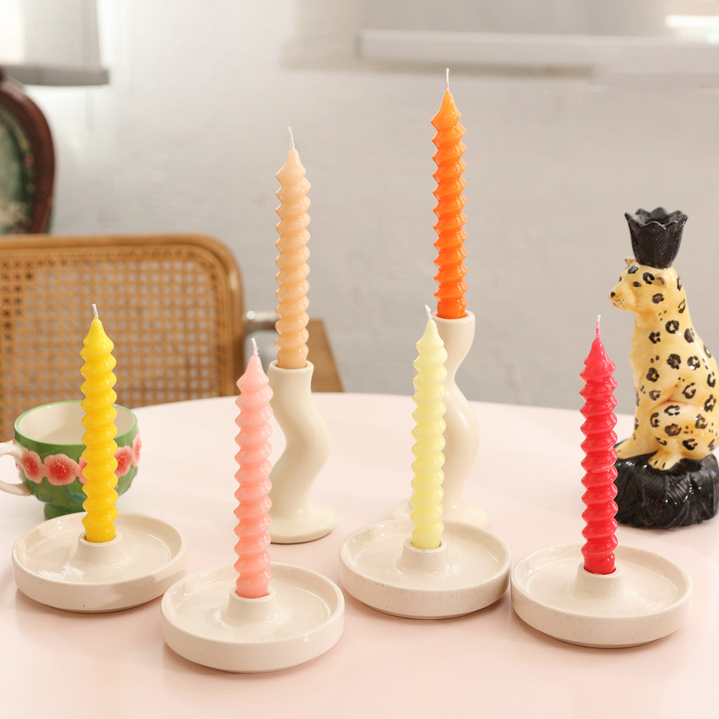 Spiral Taper Candles in different colors are placed on table candle holders.