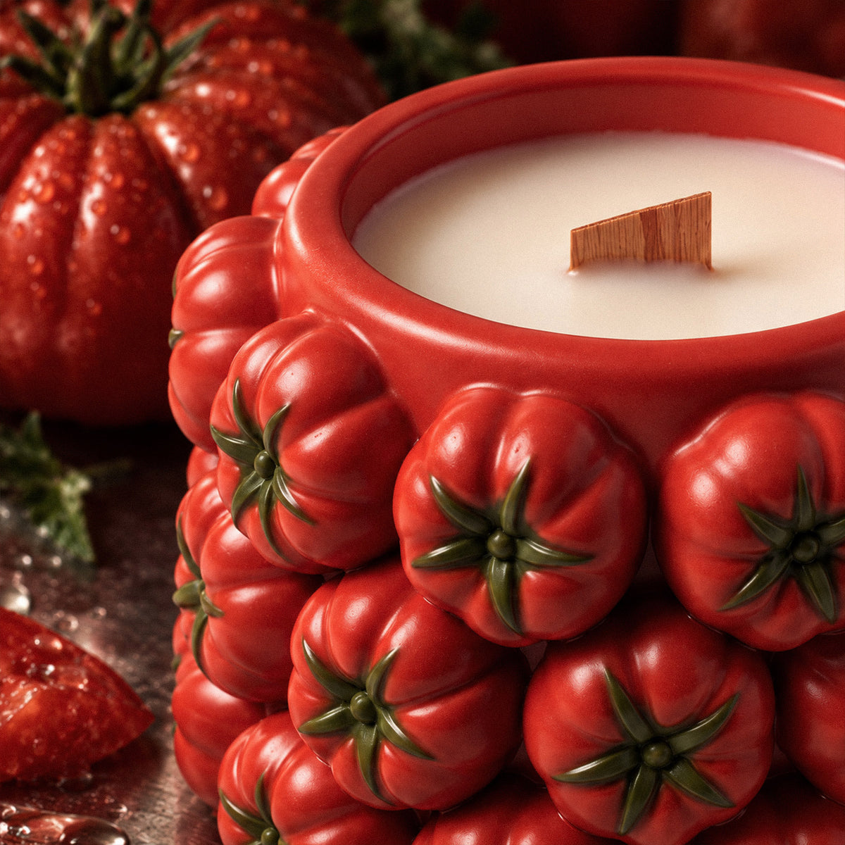 Close-up of the red tomato relief and green leaf details on a candle jar