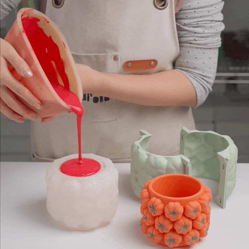 Opening the two-part silicone mold to release a tomato-cluster jar
