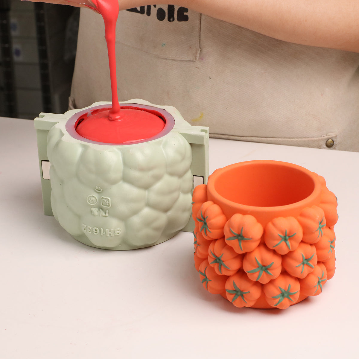 Pouring red casting mixture into the tomato-cluster silicone mold