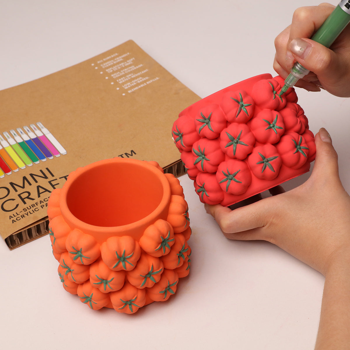 Coloring the green leaf details on a tomato-cluster jar with an acrylic marker