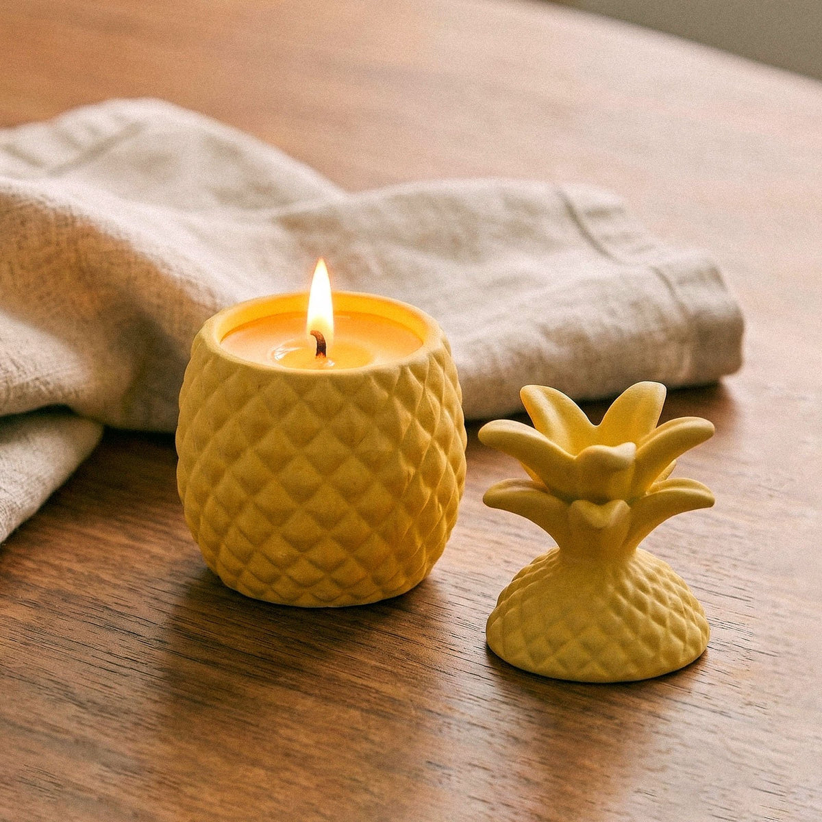 Lit yellow pineapple candle with the lid set aside
