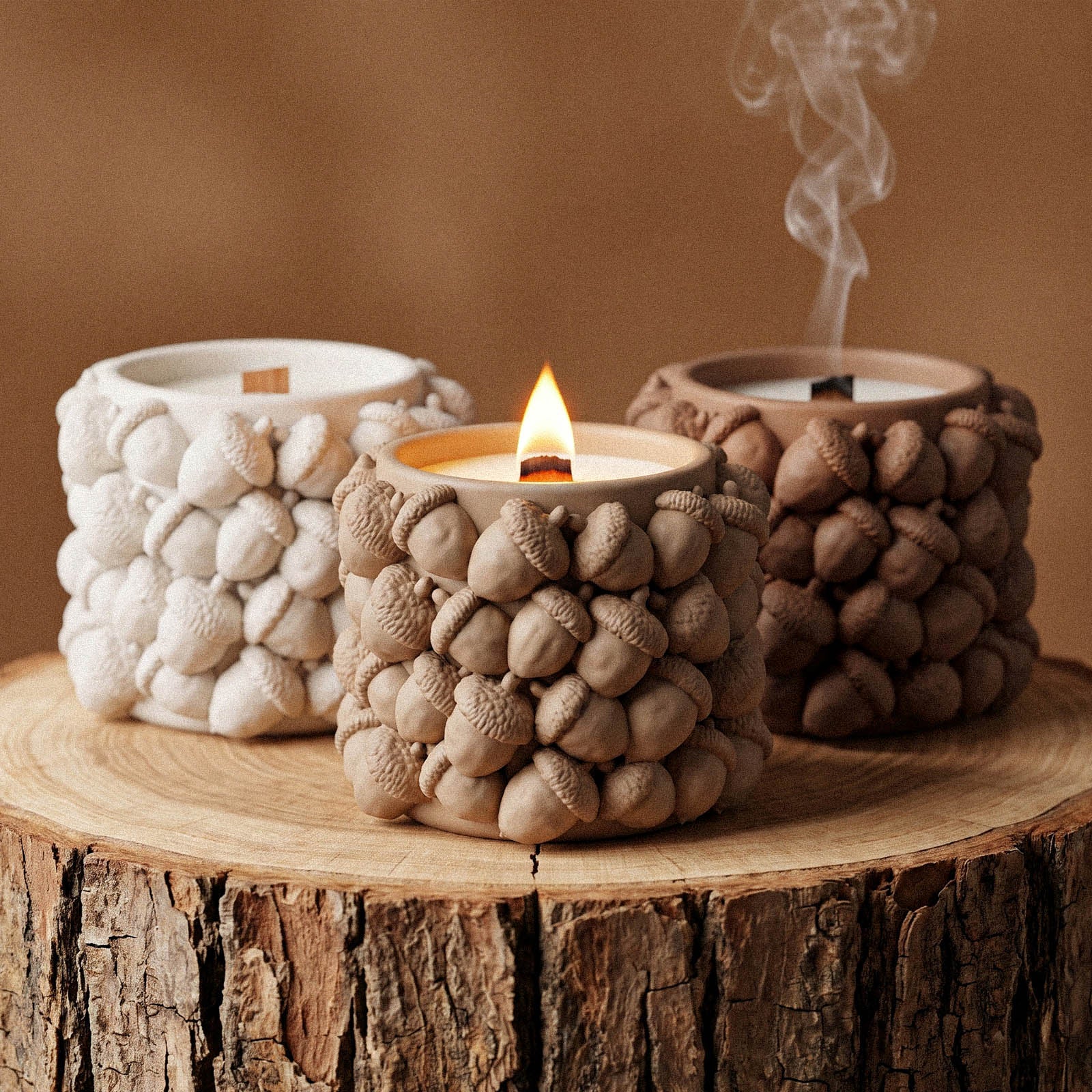 Three woodland acorn candle jars in ivory, tan, and terracotta brown, showing the range of finishes achievable from one silicone mold.