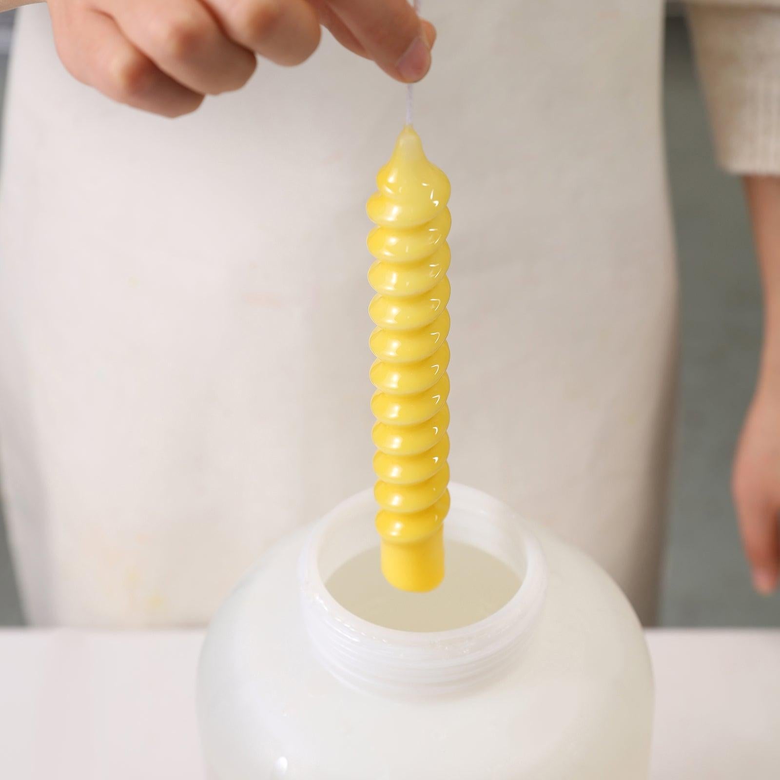 Dipping the finished candles into wax and then retrieving them