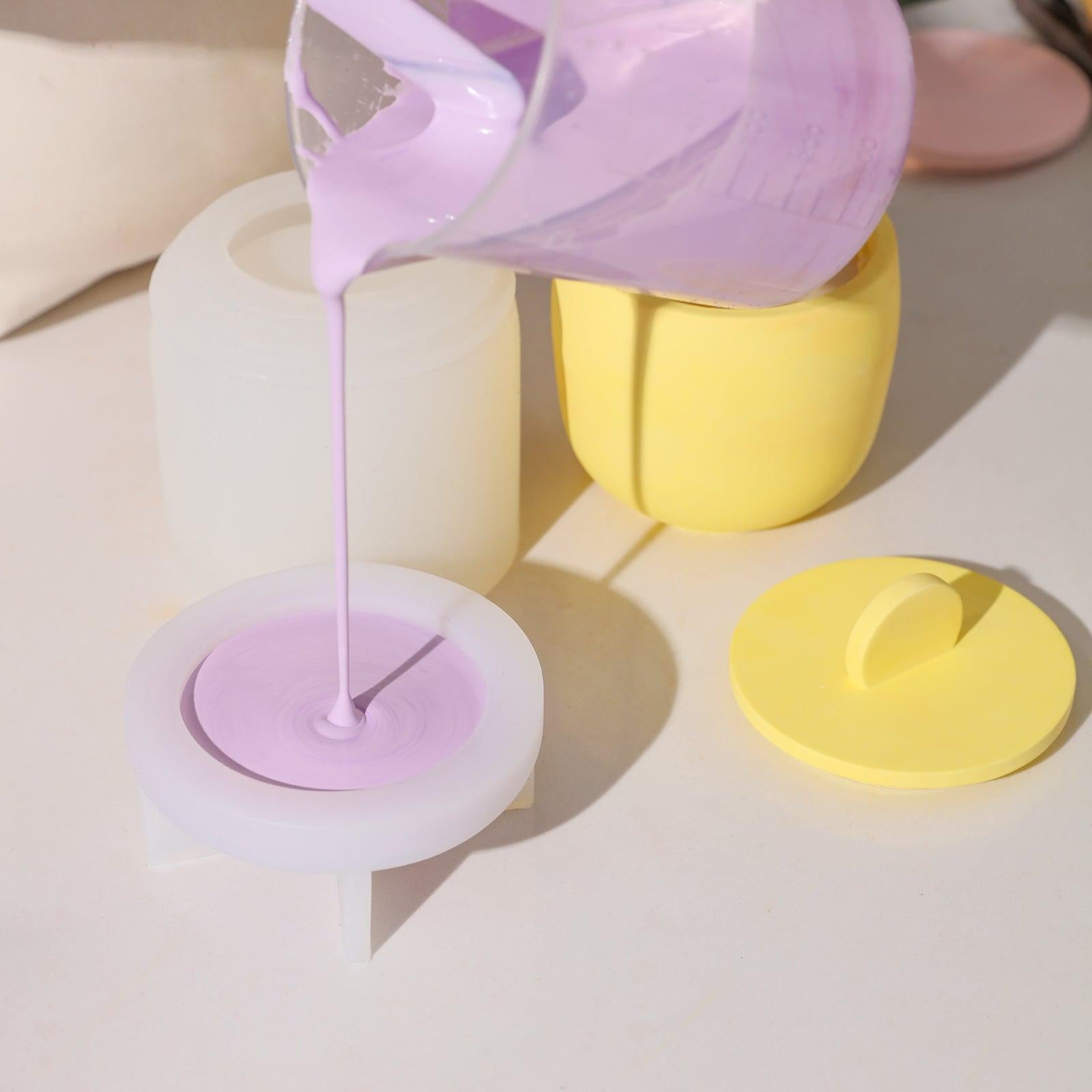 Pouring purple Boowannite material into Boowannicole's silicone mold to craft a candle jar lid.