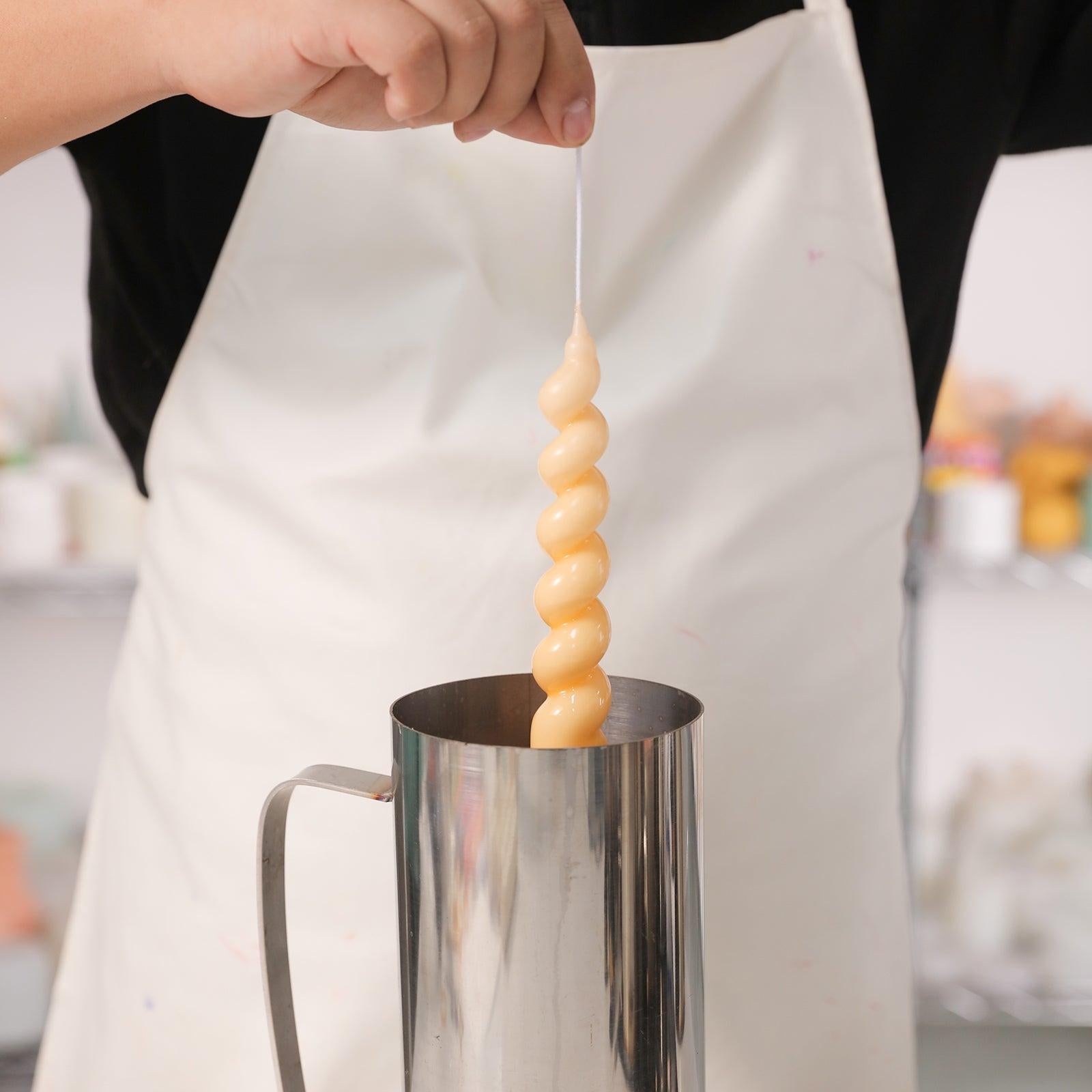 Placing Boowannicole's crafted candles into molten wax, achieving a perfect blend of artistry and craftsmanship.