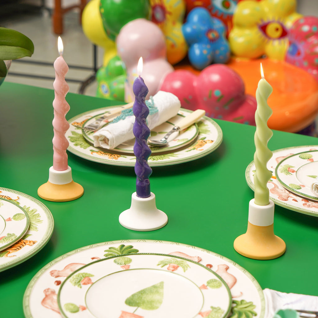 Three spiral candles arranged on a dining table.