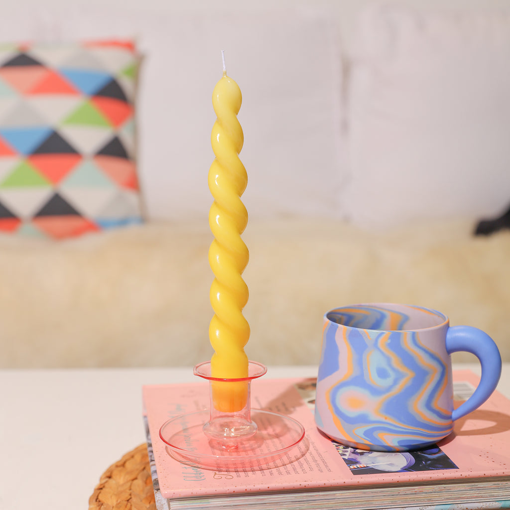Sunny Vibes - Brighten your space with a yellow cone candle, delicately placed on a tabletop, embodying warmth and charm from Boowannicole's collection.