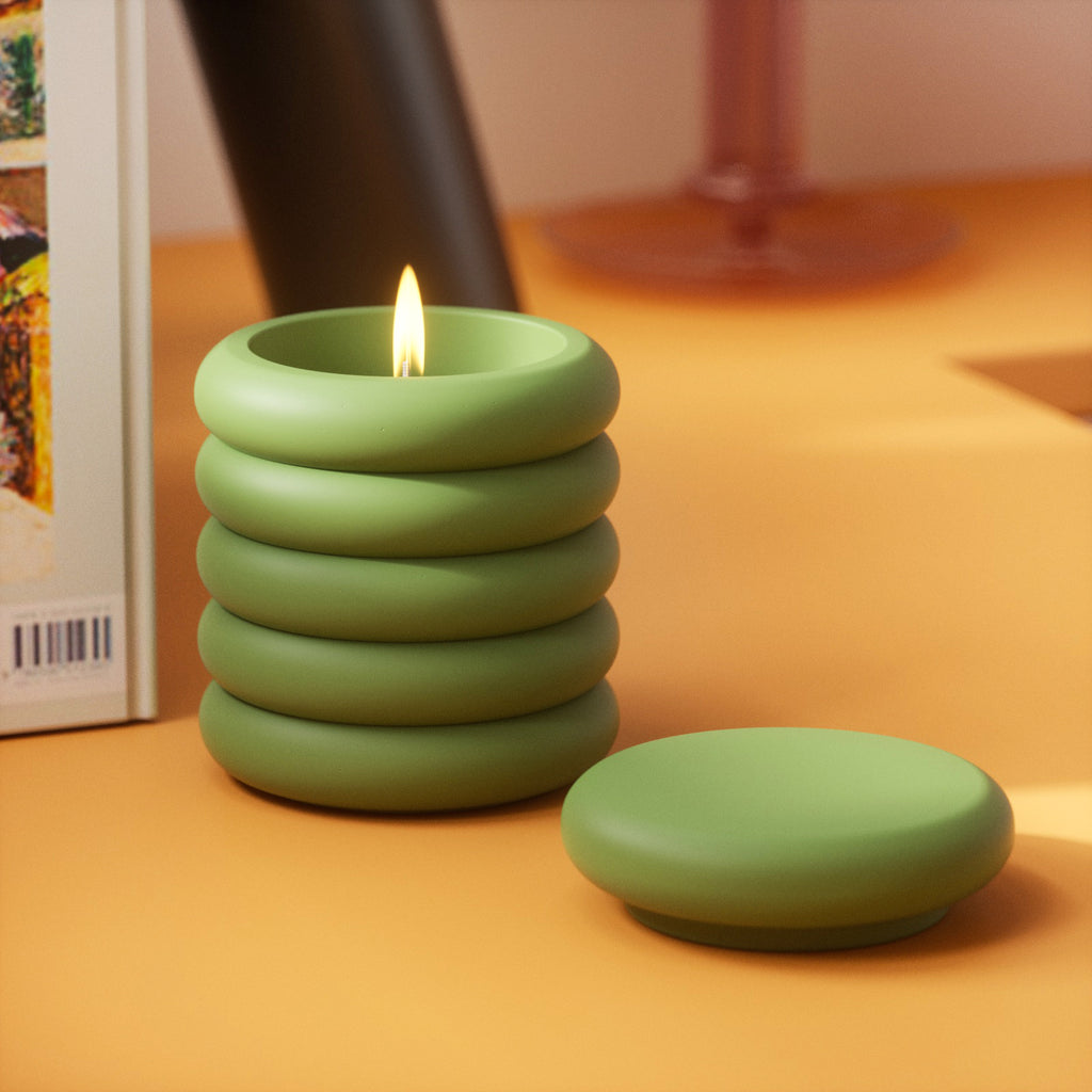 On the table, a burning candle inside Boowannicole's jar. Unique design radiates warm glow, creating a serene and cozy atmosphere.
