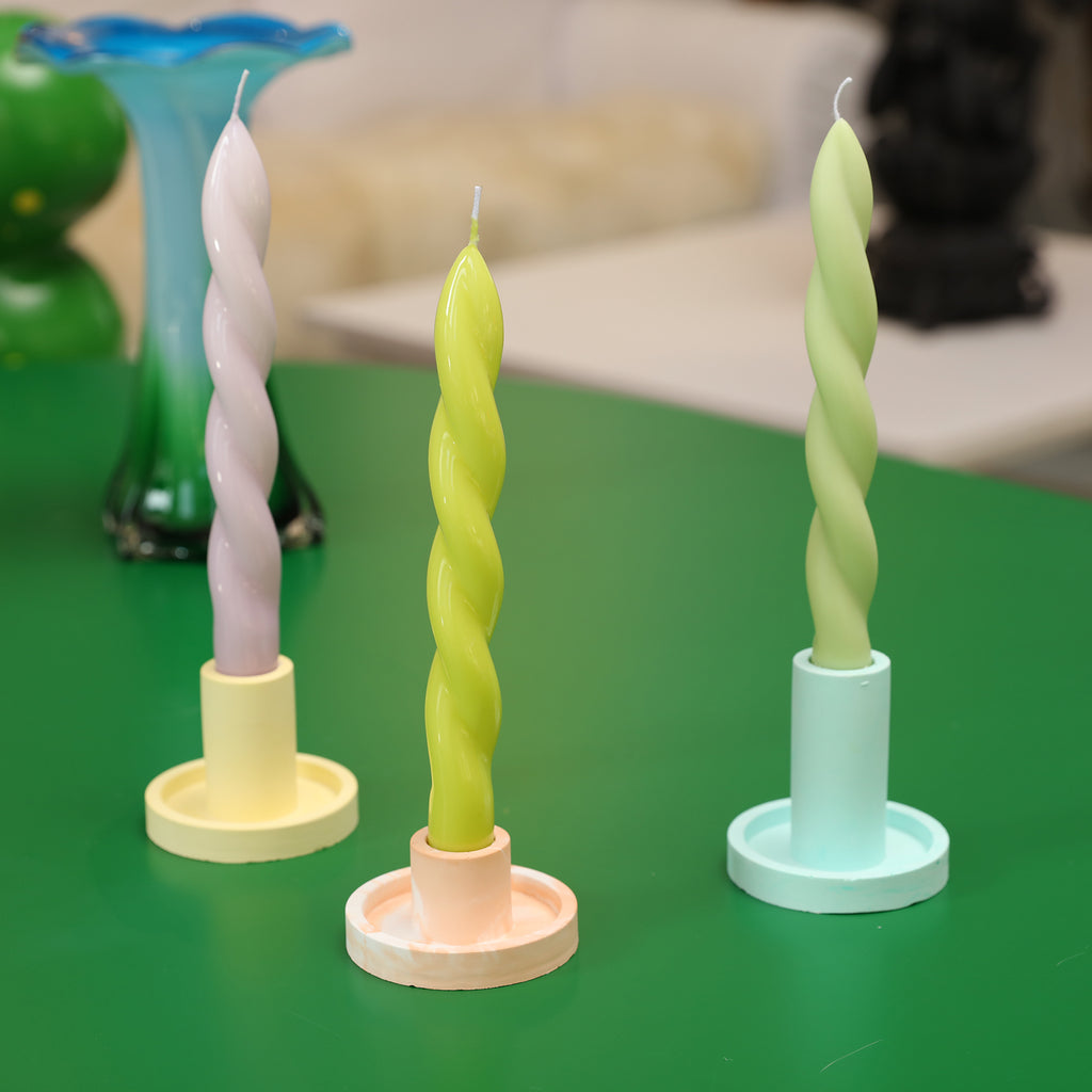 Three static display of spiral candles on a candle holder.