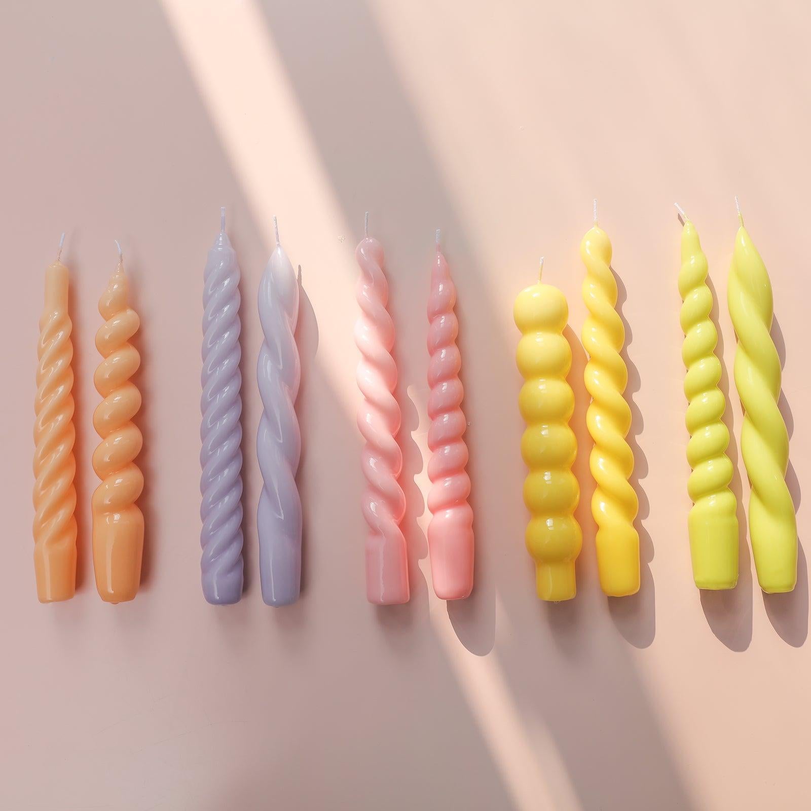 Display of candles crafted with Boowannicole's silicone molds, showcasing various colors and designs.