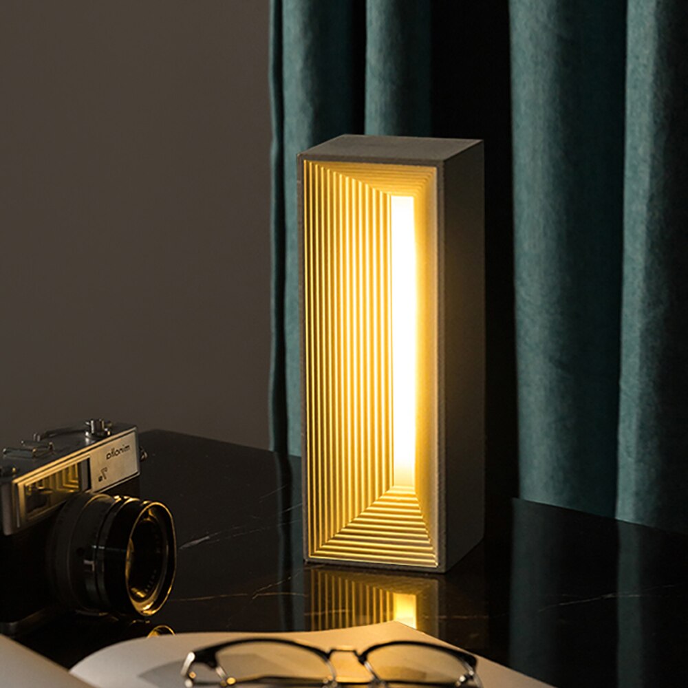 Experience the glow of creativity – behold a finished, illuminated concrete table lamp crafted with care and precision.