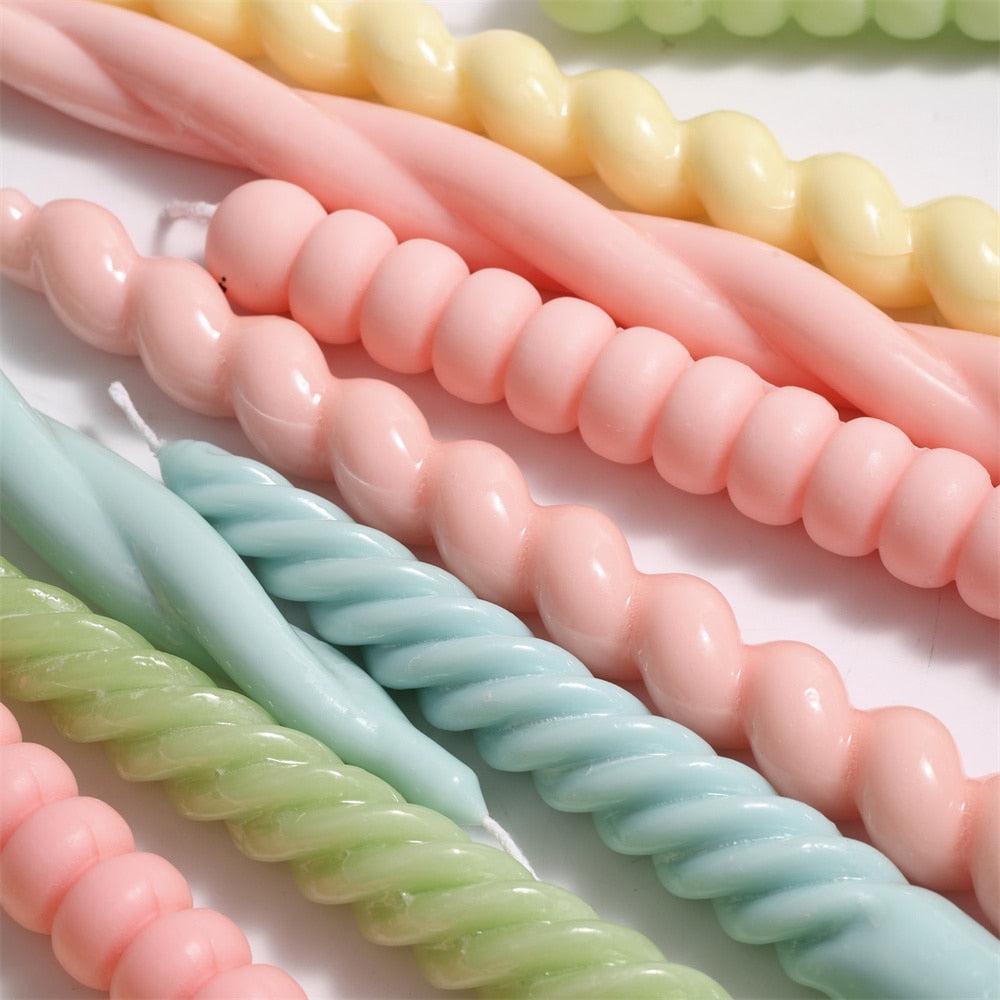 Close-up details of spiral taper candles in different colors and designs, crafted with Boowannicole silicone molds.